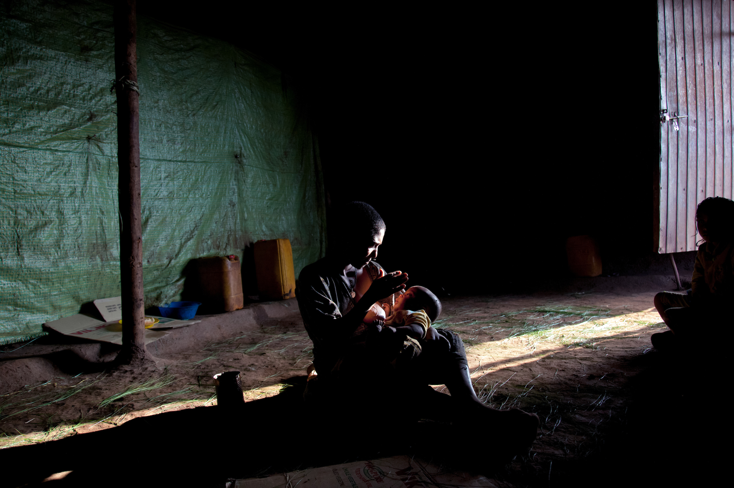 Fifteen-year-old Destaye breastfeeds her son inside her home.