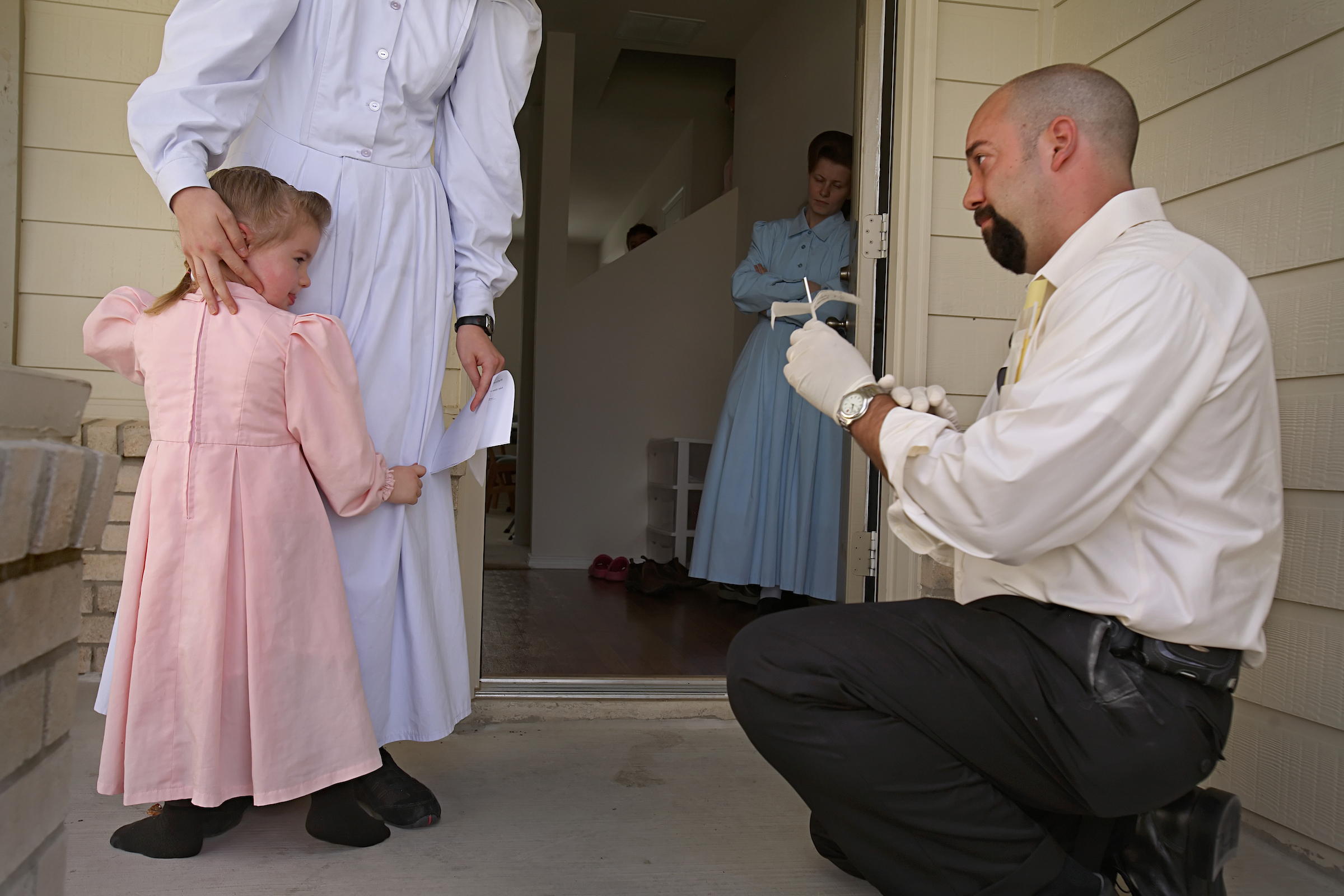 An investigator from the Texas attorney general’s office collects DNA from the 2-year-old daughter of Janet Jeffs, 19, in San Antonio.