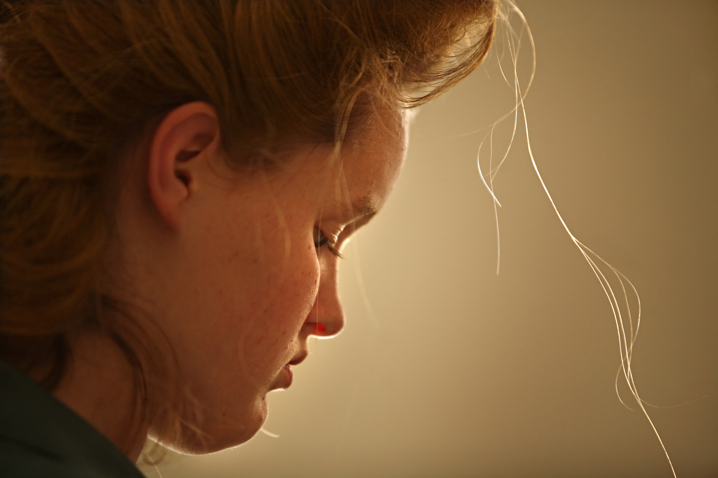 Josephine Jeffs, 15, looks down while braiding the hair of sister, both daughters of FLDS leader Warren Jeffs.