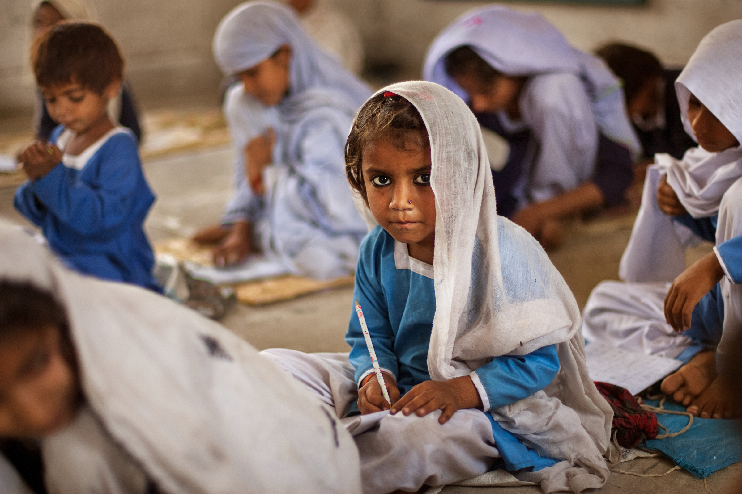 Uzma, 4, learns how to write the alphabet at a school created by a gang rape survivor in Meerwala, Pakistan. 